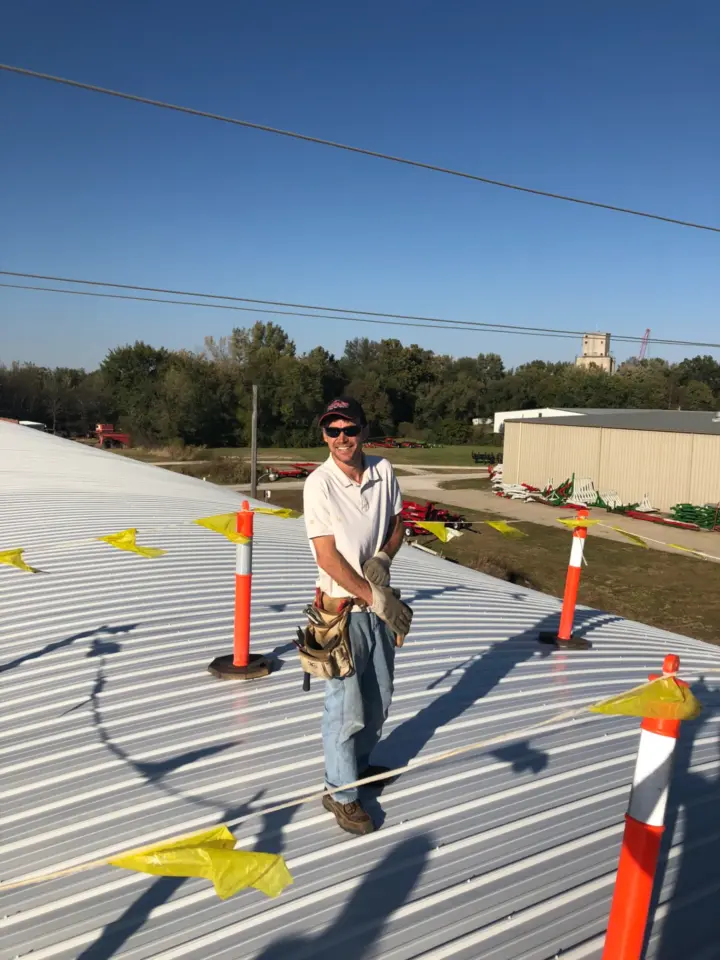 David standing on newly finished metal roof in 2018