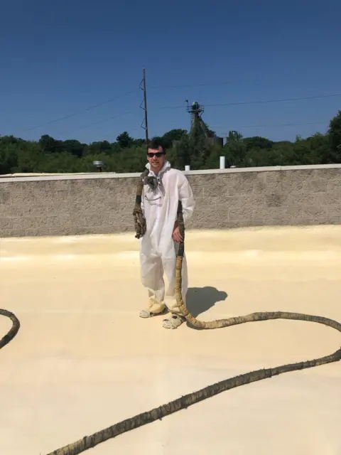 David standing on roof after finishing commercial spray foam job