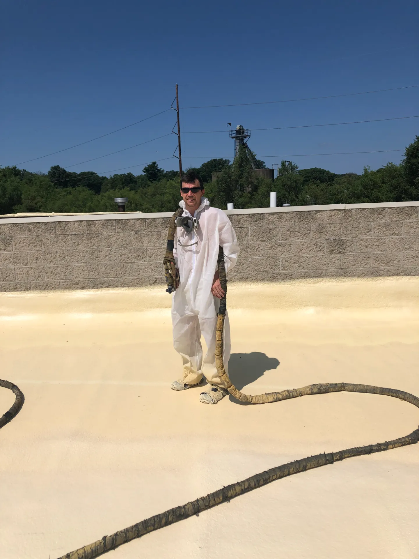 David standing on roof after finishing commercial spray foam job